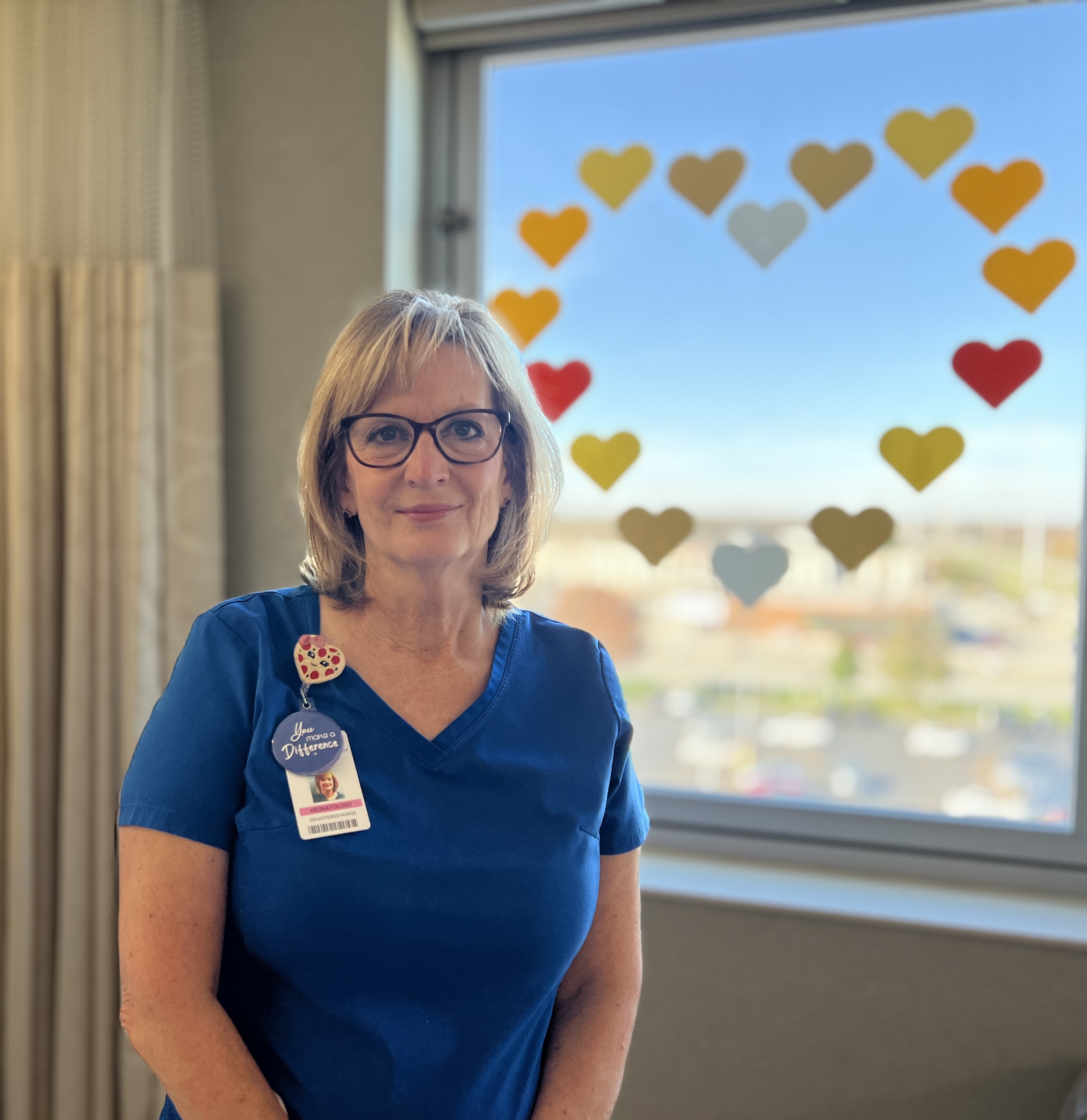 Pamela Companik standing in front of a window with a heart on it
